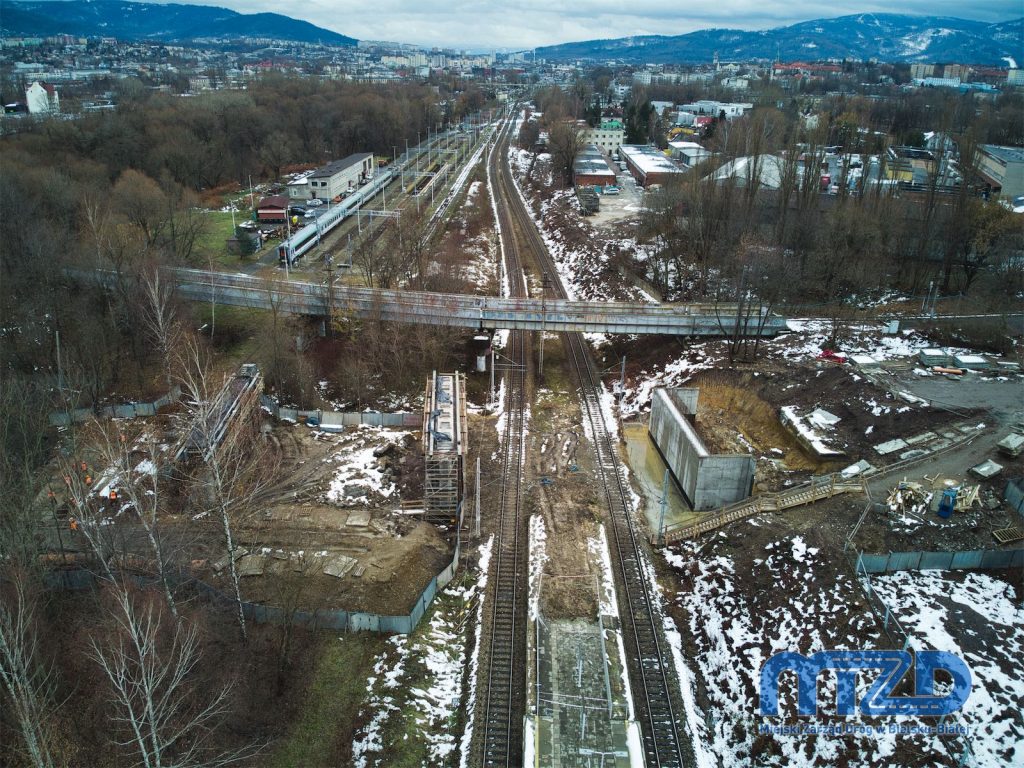 Szeroki widok na rejon budowy wiaduktu nad linią kolejową z panoramą Bielska-Białej w kierunku południowym.