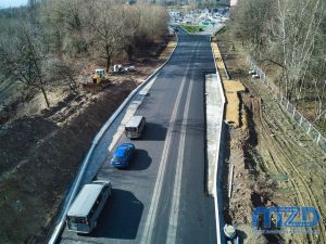 03. Niski widok z drona na odcinek pokryty warstwą podbudowy asfaltowej i dwie betonowe zatoki autobusowe.