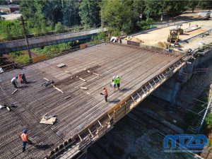 018 – Zbliżenie na budowlańców pracujących na zbrojonej płycie wiaduktu.