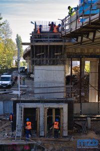 023. Ekipa budowlana wznosząca betonowy szyb windy.